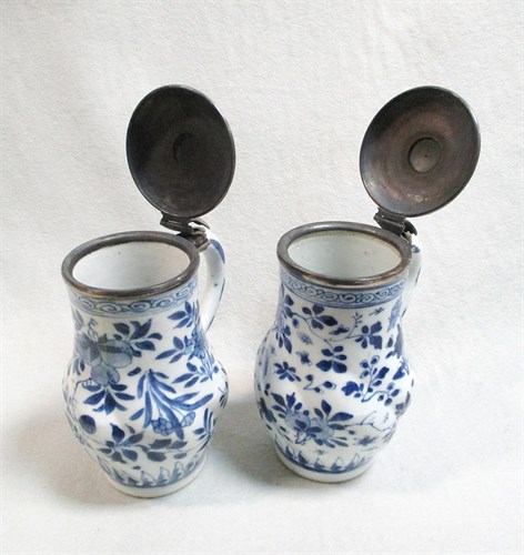 Lot 128 - A pair of Transitional blue and white lidded tankards