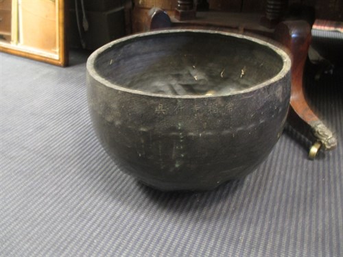 Lot 250 - A Chinese bowl gong with beater on a red...