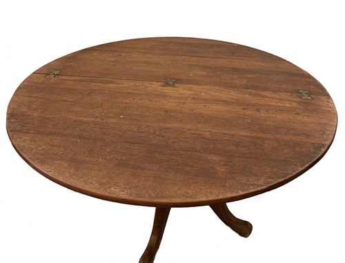 Lot 40 - A limed oak circular kitchen table with hinged folding top
