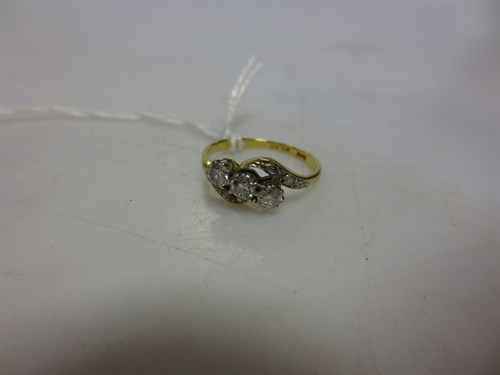 Lot 282 - A three stone cross over style diamond set...