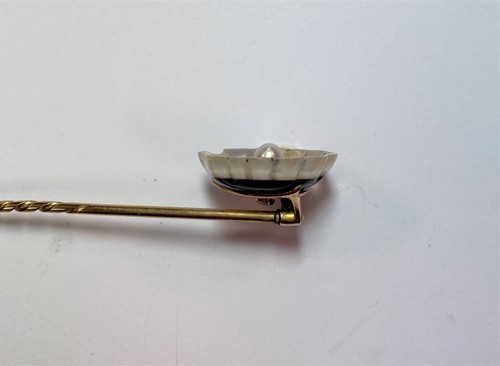 Lot 24 - A shell cameo brooch and a banded agate and pearl set stick pin