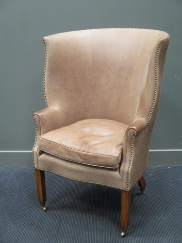 Lot 360 - A leather upholstered barrel back easy chair...