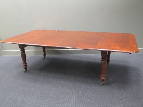 Lot 319 - A mahogany extending dining table with two...