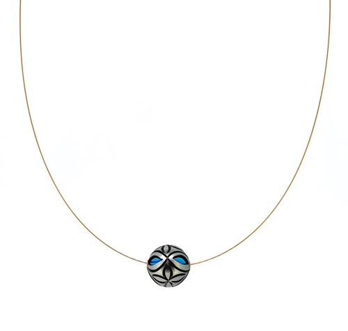 Lot 101 - A carved Tahitian cultured pearl pendant with turquoise bead interior and wire