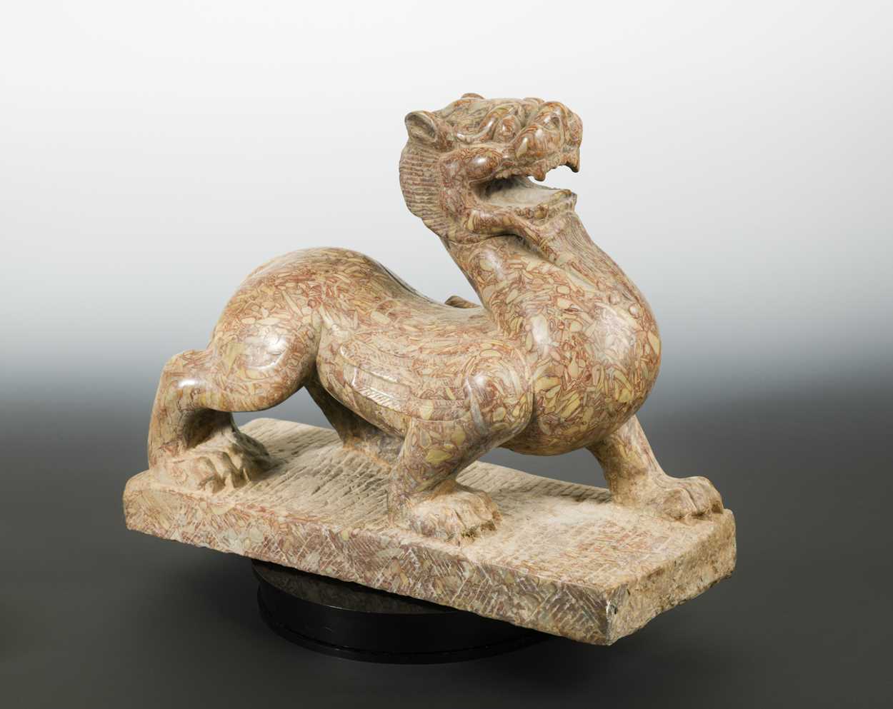 Lot 150 - A red pudding stone carving of a Crouched Pixiu/Chimera, Northern Qi Dynasty style