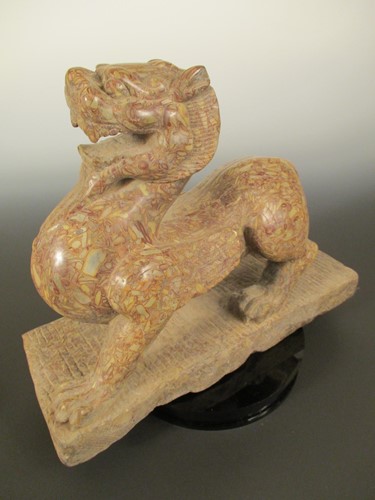 Lot 150 - A red pudding stone carving of a Crouched Pixiu/Chimera, Northern Qi Dynasty style
