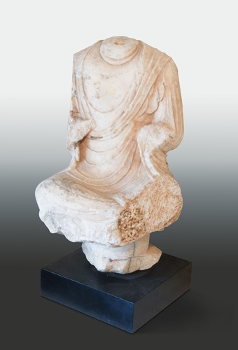 Lot 112 - A Chinese white marble seated Buddha on a pedestal, headless, Northern Wei style