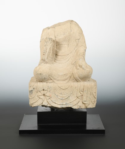 Lot 125 - A Chinese grey stone seated Buddhist deity, headless, perhaps Wei Dynasty