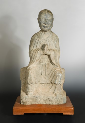 Lot 137 - A Chinese stone seated Arhat, perhaps Tang Dynasty (618 AD - 907 AD)
