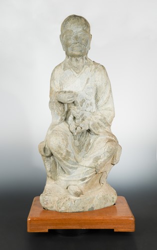 Lot 138 - A Chinese stone seated Arhat, perhaps Tang Dynasty (618 AD - 907 AD)