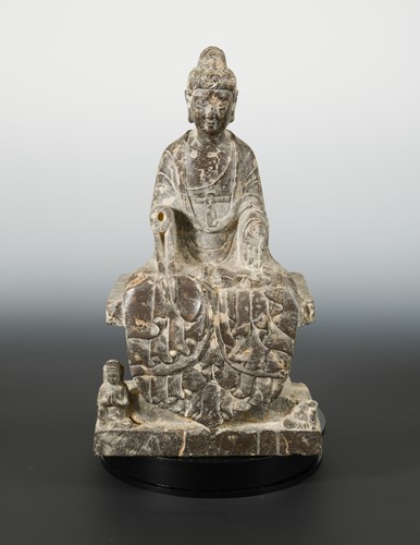 Lot 178 - A Chinese mottled dark stone seated Buddhist deity, in Wei Dynasty style