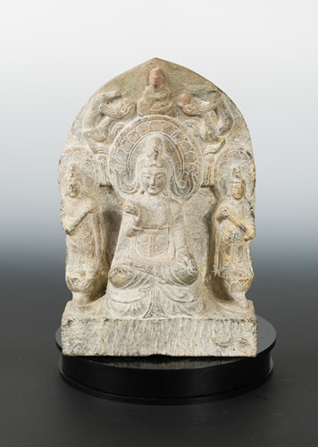 Lot 243 - A Chinese grey stone Buddhist triad stele with aureole, in Wei Dynasty style
