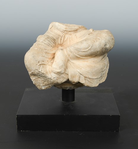 Lot 247 - A Chinese white marble fragmentary figure of a seated Buddhist deity, in 6th/7th century style