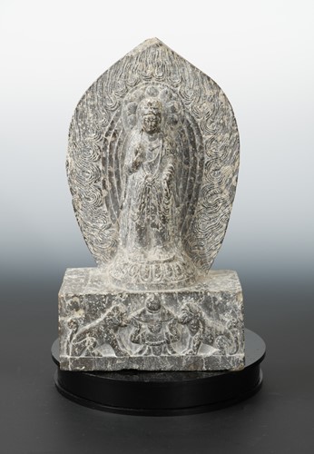 Lot 260 - A Chinese carved stone standing figure of Avalokiteshvara with aureole, in Wei Dynasty style