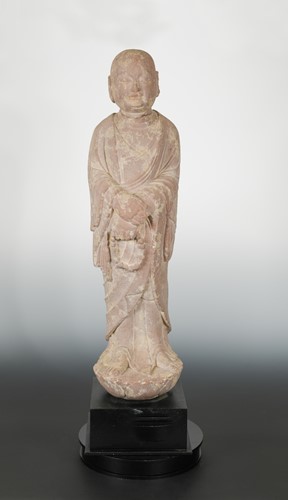 Lot 266 - A Chinese red sandstone standing arhat, in Tang Dynasty style