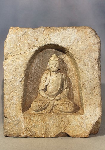 Lot 267 - A Chinese cream stone figure of a seated Buddha in a niche, in 5-6th century style