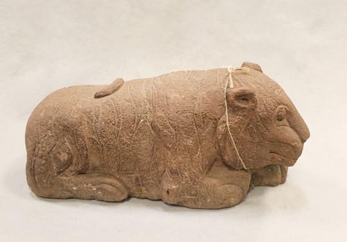 Lot 269 - A Chinese red sandstone recumbent tiger, perhaps Han Dynasty, with striped coat