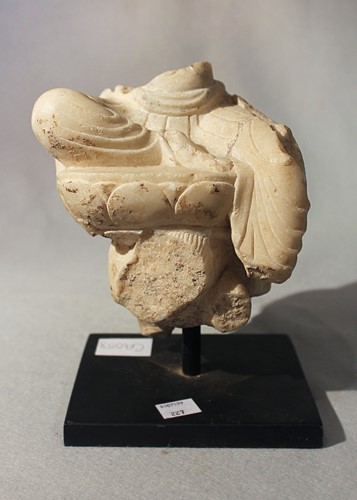 Lot 289 - A white marble fragment of a deity on lotus dais on horseback, in Tang style