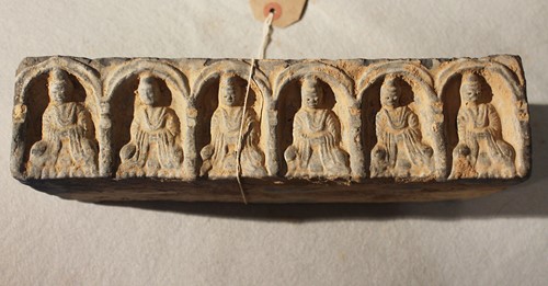 Lot 290 - A Chinese grey pottery rectangular brick with an arcade of six Buddhas, in Tang Dynasty style