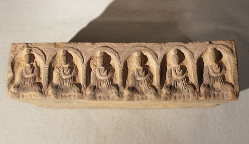 Lot 291 - A Chinese grey pottery rectangular brick with an arcade of six Buddhas, in Tang Dynasty style