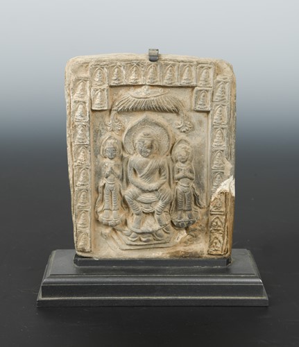 Lot 297 - A Chinese grey clay tile depicting a Buddha triad, in Northern Wei style