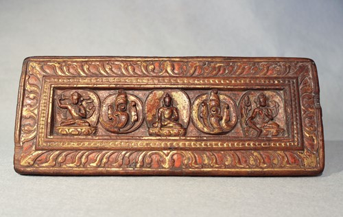 Lot 387 - A Tibetan carved and parcel gilt-wood manuscript cover, 14th/15th century or later
