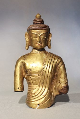 Lot 388 - A Nepalese gilt-copper repousse upper torso of a Buddha, 18th century