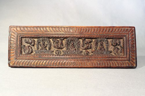 Lot 394 - A Tibetan carved wood manuscript cover, 14th/15th century or later