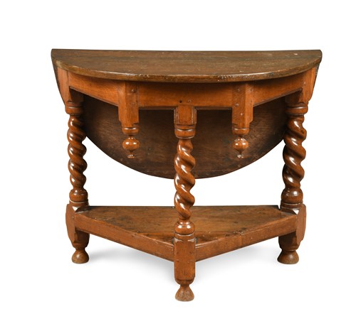 Lot 143 - A 17th century style oak three-legged drop flap table