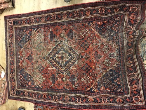 Lot 650 - A worn red and blue patterned rug, 194 x 132cm;...