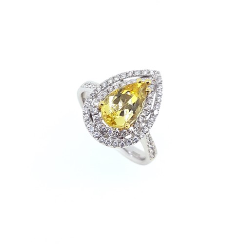 Lot 99 - A golden beryl and diamond halo style ring