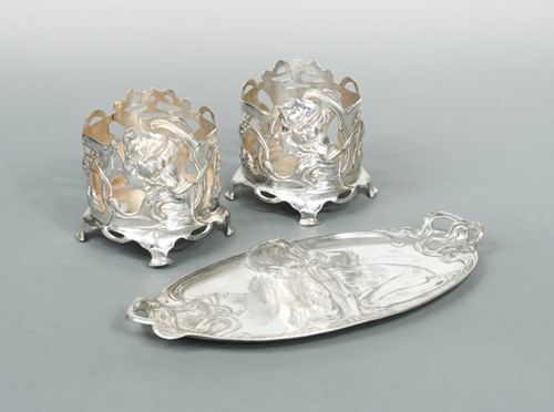 Lot 300 - A German metalwares dressing table tray and a pair of bottle coasters all in the Art Nouveau style