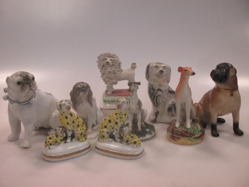 Lot 42 - A group of nine small ceramic model dogs,...