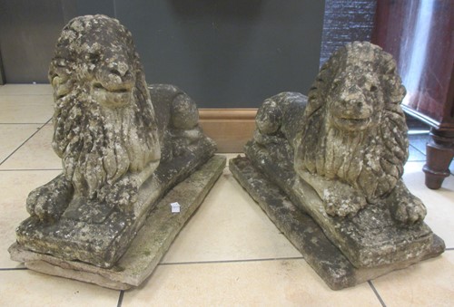 Lot 450 - A pair of reconstituted stone recumbent lions (2)