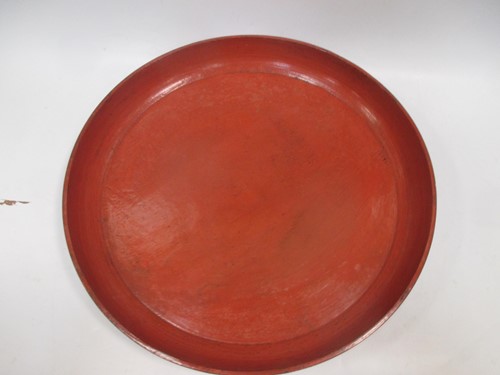 Lot 32 - A large red painted wooden platter, 53cm diameter