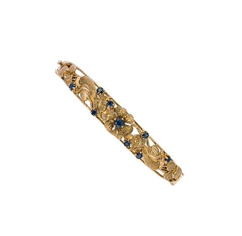 Lot 19 - A late 20th century sapphire hinged bangle
