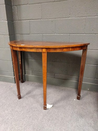 Lot 567 - An inlaid demi-lune console table raised on...