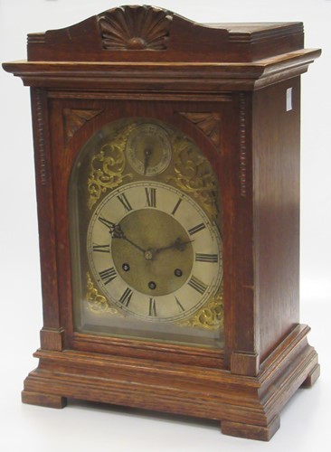 Lot 199 - An Edwardian oak mantle clock, the brass dial...