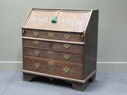 Lot 368 - A carved oak bureau in the Gothic style, the...