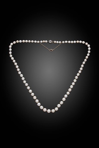 Lot 255 - A string of natural saltwater pearls with a diamond set clasp