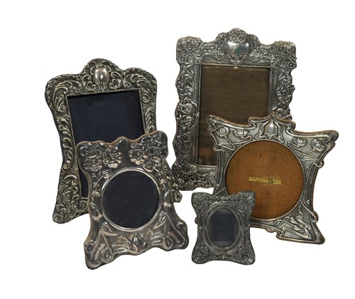 Lot 590 - Four early 20th century silver easel back photograph frames together with a later example