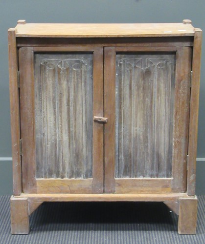 Lot 404 - A small limed oak cupboard with gothic linen...