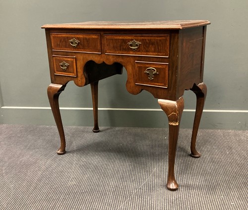 Lot 426 - A walnut lowboy fitted with four drawers...