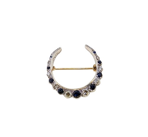 Lot 110 - A late 20th century 9ct gold, sapphire and diamond crescent brooch