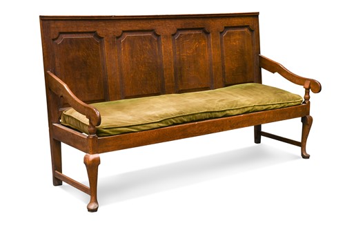 Lot 382 - A George III oak panel back settle
