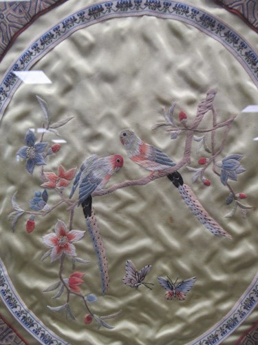 Lot 262 - An oval Chinese textile love birds, 39 x 34cm