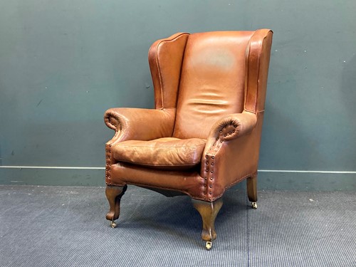 Lot 424 - A modern brown leather wingback armchair 111 x...