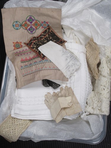 Lot 167 - A box of various textiles: cross stitch...