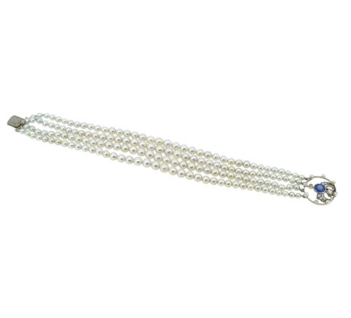 Lot 197 - A four row pearl bracelet with a sapphire and diamond clasp