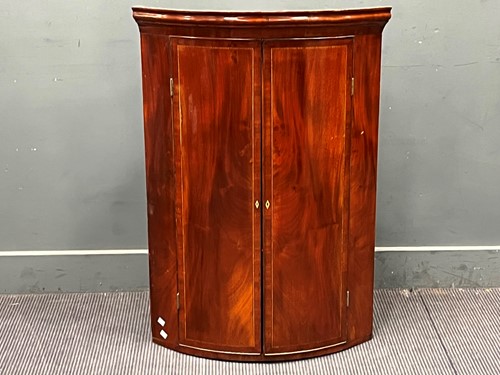 Lot 568 - A George III mahogany bow front corner...